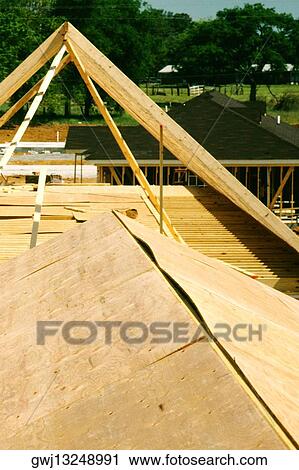 Stock Image - Close-up of the wooden frame of a house under construction. Fotosearch