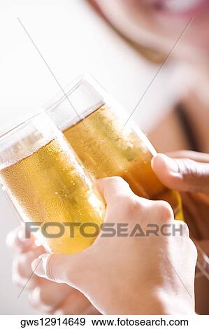 Close-up of two men and a woman toasting champagne flutes View Large Photo Image Stock Photo - Close-up of two men and a woman toasting champagne flutes. Fotosearch