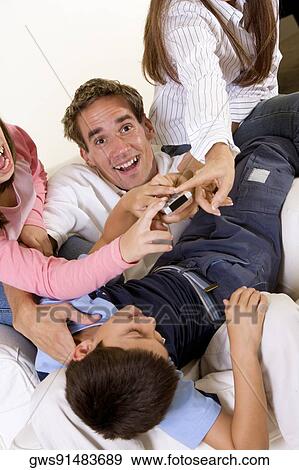 Stock Photo - Four people pressing buttons on a remote control. Fotosearch