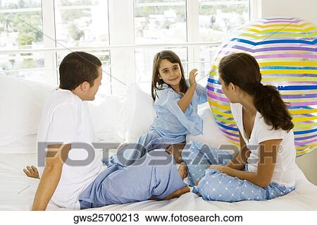 Girl and her parents playing with a ball View Large Photo Image Stock Image - Girl and her parents playing with a ball. Fotosearch