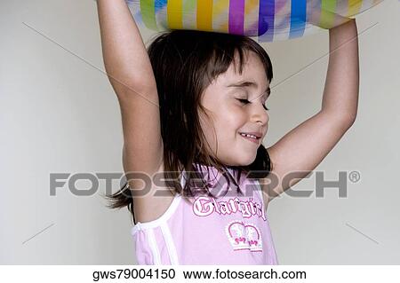 Girl carrying an inflatable ball over her head View Large Photo Image Stock Image - Girl carrying an inflatable ball over her head. Fotosearch