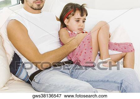 Girl sitting on her father's lap View Large Photo Image Stock Photo - Girl sitting on her father's lap. Fotosearch