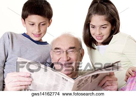 Grandfather reading a newspaper with his grandson and his granddaughter View Large Photo Image Picture - Grandfather reading a newspaper with his grandson and his granddaughter. Fotosearch