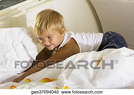 High angle view of a boy lying on the bed View Large Photo Image Stock Image - High angle view of a boy lying on the bed. Fotosearch