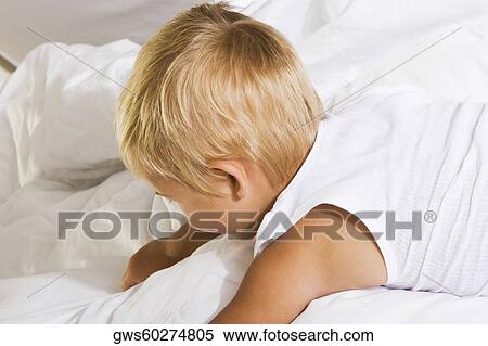 High angle view of a boy lying on the bed View Large Photo Image Stock Photography - High angle view of a boy lying on the bed. Fotosearch