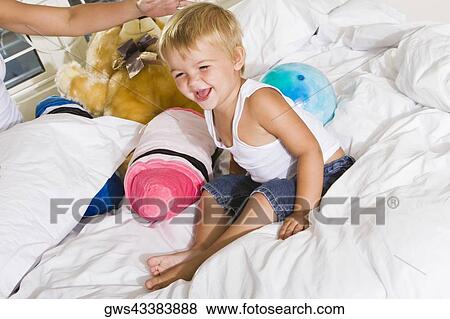 High angle view of a boy sitting on a bed laughing View Large Photo Image Stock Photo - High angle view of a boy sitting on a bed laughing. Fotosearch