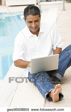 High angle view of a mid adult man using a laptop View Large Photo Image Stock Photography - High angle view of a mid adult man using a laptop. Fotosearch