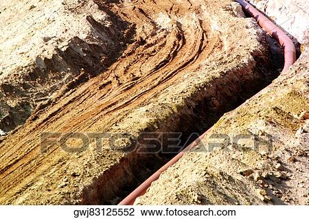 Stock Image - High angle view of a pipeline in a ditch. Fotosearch