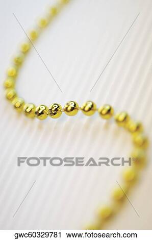 High angle view of a string of golden beads View Large Photo Image Stock Image - High angle view of a string of golden beads. Fotosearch