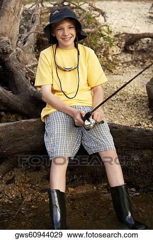 Stock Photo - High angle view of a teenage boy holding a fishing rod. Fotosearch