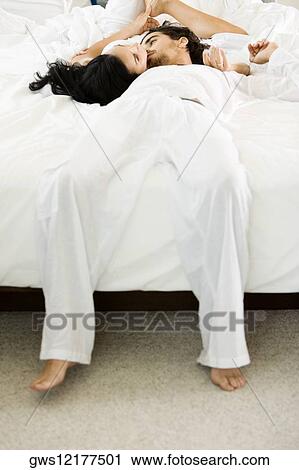 High angle view of a young couple lying on the bed View Large Photo Image Stock Image - High angle view of a young couple lying on the bed. Fotosearch