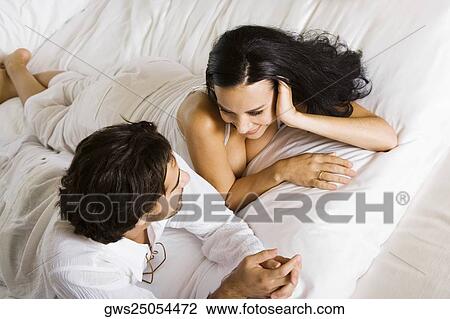 High angle view of a young couple lying down on a bed View Large Photo Image Stock Image - High angle view of a young couple lying down on a bed. Fotosearch