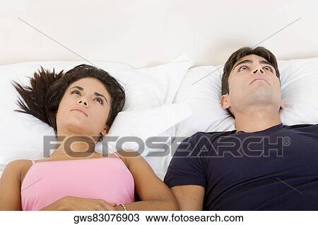 High angle view of a young couple lying on the bed and looking up View Large Photo Image Stock Image - High angle view of a young couple lying on the bed and looking up. Fotosearch