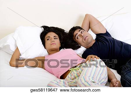 High angle view of a young couple lying on the bed View Large Photo Image Stock Photo - High angle view of a young couple lying on the bed. Fotosearch