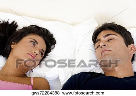 High angle view of a young couple lying on the bed View Large Photo Image Stock Photo - High angle view of a young couple lying on the bed. Fotosearch