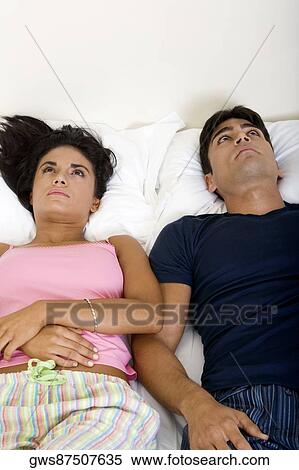 High angle view of a young couple lying on the bed looking up View Large Photo Image Stock Photography - High angle view of a young couple lying on the bed looking up. Fotosearch