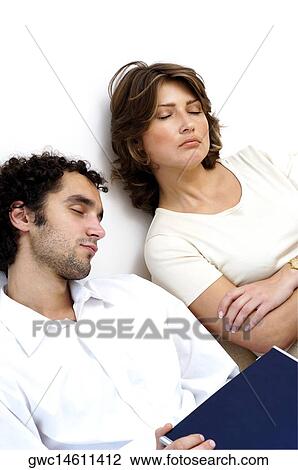 High angle view of a young couple sleeping against a wall View Large Photo Image Stock Image - High angle view of a young couple sleeping against a wall. Fotosearch