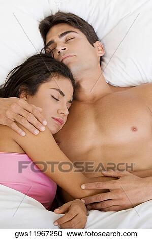 High angle view of a young couple sleeping on a bed View Large Photo Image Stock Image - High angle view of a young couple sleeping on a bed. Fotosearch
