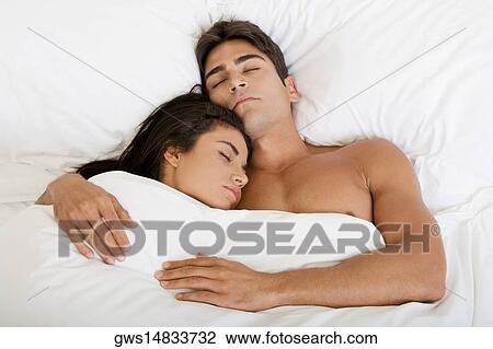 High angle view of a young couple sleeping on a bed View Large Photo Image Stock Image - High angle view of a young couple sleeping on a bed. Fotosearch