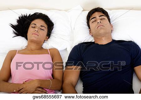 High angle view of a young couple sleeping on a bed View Large Photo Image Stock Photo - High angle view of a young couple sleeping on a bed. Fotosearch
