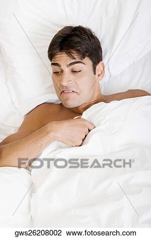 High angle view of a young man lying on the bed View Large Photo Image Stock Image - High angle view of a young man lying on the bed. Fotosearch