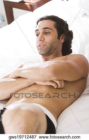 High angle view of a young man lying on the bed View Large Photo Image Stock Photo - High angle view of a young man lying on the bed. Fotosearch