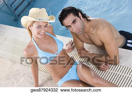High angle view of a young woman and a mid adult man at the poolside View Large Photo Image Stock Image - High angle view of a young woman and a mid adult man at the poolside. Fotosearch