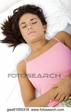 High angle view of a young woman sleeping on a bed View Large Photo Image Stock Photo - High angle view of a young woman sleeping on a bed. Fotosearch
