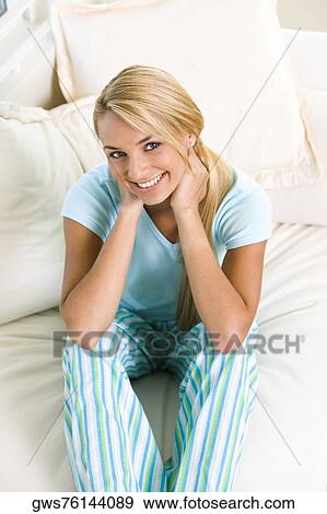 High angle view of a young woman sitting on a bed View Large Photo Image Stock Photo - High angle view of a young woman sitting on a bed. Fotosearch