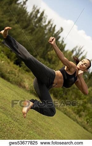 Stock Photography - Low angle view of a mid adult woman practicing martial arts. Fotosearch