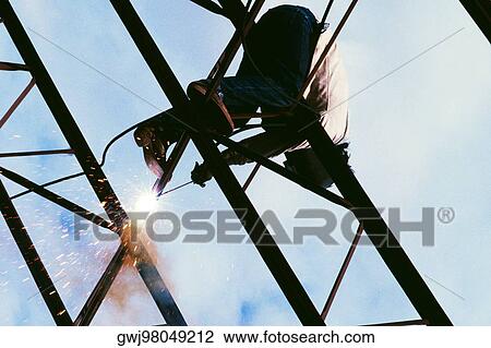 Low angle view of a welder on a metal structure View Large Photo Image Stock Image - Low angle view of a welder on a metal structure. Fotosearch
