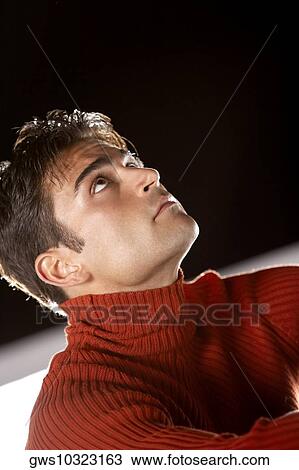 Low angle view of a young man looking up View Large Photo Image Stock Image - Low angle view of a young man looking up. Fotosearch