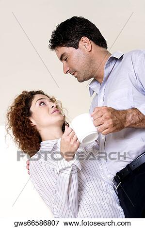 Low angle view of a young woman and a mid adult man holding coffee cups View Large Photo Image Stock Photo - Low angle view of a young woman and a mid adult man holding coffee cups. Fotosearch