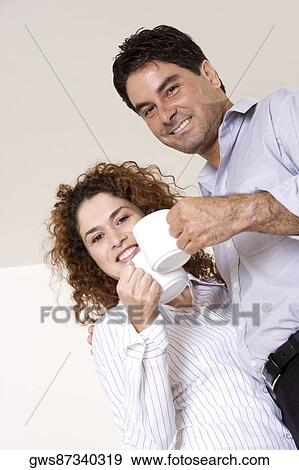 Low angle view of a young woman and a mid adult man holding coffee cups View Large Photo Image Stock Photo - Low angle view of a young woman and a mid adult man holding coffee cups. Fotosearch