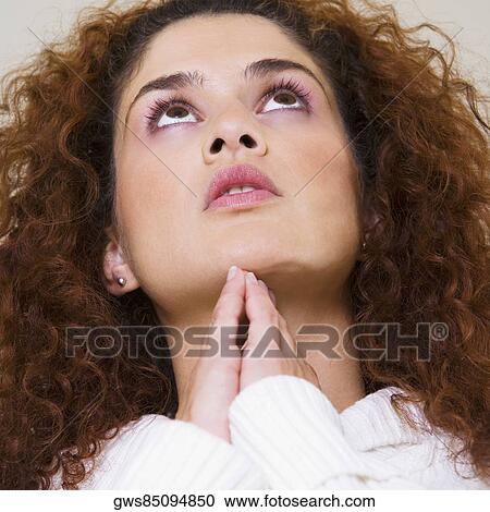 Low angle view of a young woman looking up View Large Photo Image Stock Image - Low angle view of a young woman looking up. Fotosearch