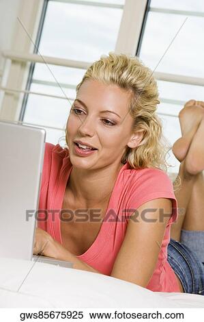 Low angle view of a young woman working on a laptop View Large Photo Image Stock Photography - Low angle view of a young woman working on a laptop. Fotosearch