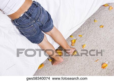 Picture - Low section view of a boy leaning over the bed. Fotosearch