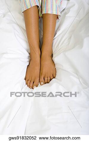 Low section view of a woman on the bed View Large Photo Image Stock Image - Low section view of a woman on the bed. Fotosearch