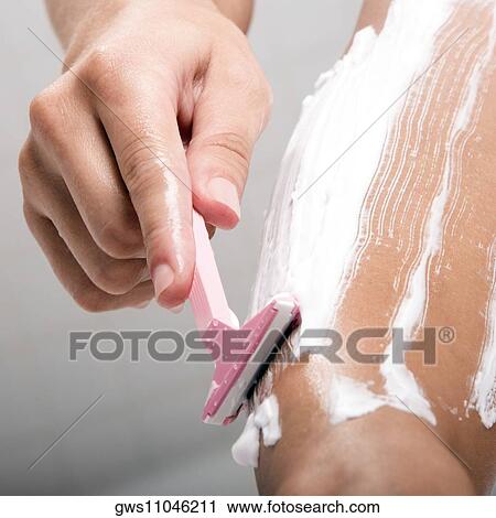 Low section view of a woman shaving her leg with a razor View Large Photo Image Stock Image - Low section view of a woman shaving her leg with a razor. Fotosearch