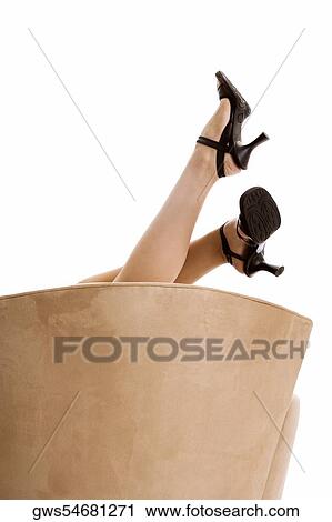 Stock Image - Low section view of a young woman wearing stilettos. Fotosearch