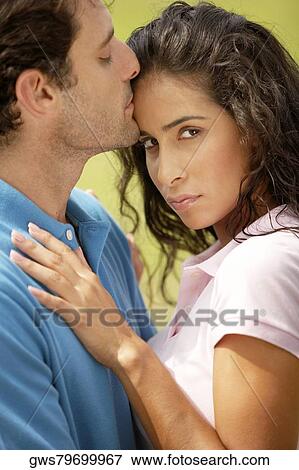 Mid adult man kissing a young woman on her forehead View Large Photo Image Stock Photo - Mid adult man kissing a young woman on her forehead. Fotosearch