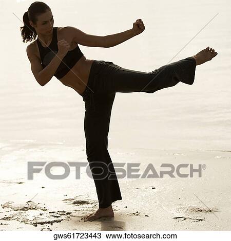 Stock Image - Mid adult woman practicing martial arts. Fotosearch
