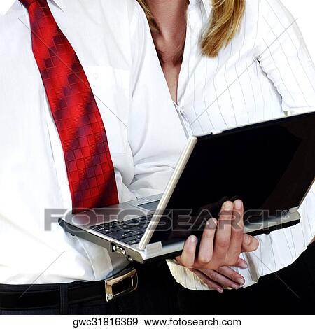 Stock Photo - Mid section view of a businessman holding a laptop with a businesswoman standing beside him. Fotosearch