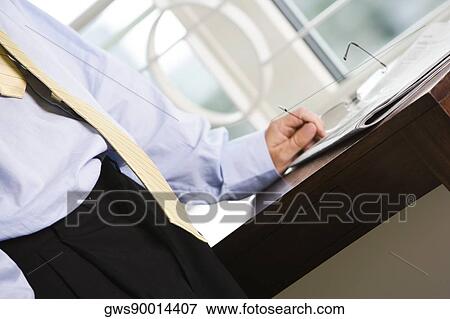 Mid section view of a businessman standing near a table View Large Photo Image Stock Photo - Mid section view of a businessman standing near a table. Fotosearch
