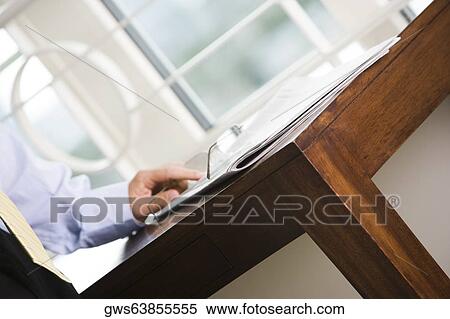 Mid section view of a businessman standing near a table View Large Photo Image Stock Photography - Mid section view of a businessman standing near a table. Fotosearch
