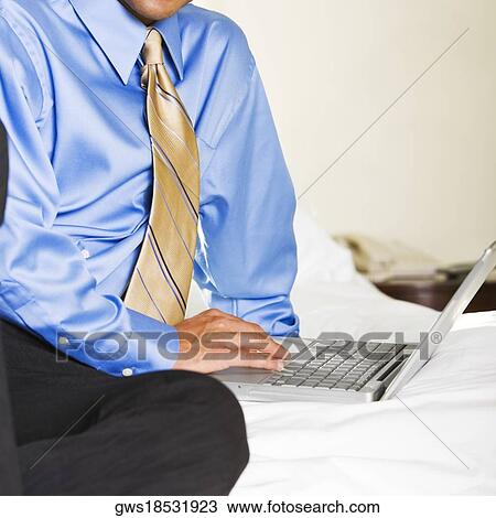 Mid section view of a businessman using a laptop View Large Photo Image Stock Image - Mid section view of a businessman using a laptop. Fotosearch