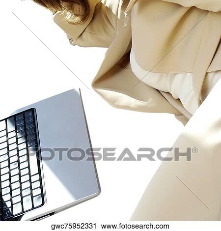 Stock Image - Mid section view of a businesswoman lying in front of a laptop. Fotosearch