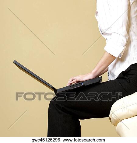 Mid section view of a businesswoman using a laptop View Large Photo Image Stock Photograph - Mid section view of a businesswoman using a laptop. Fotosearch