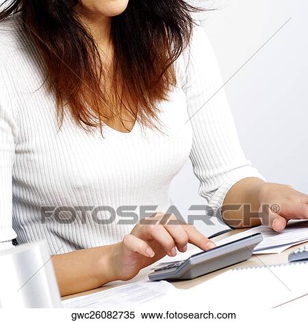 Stock Photography - Mid section view of a businesswoman using a calculator. Fotosearch