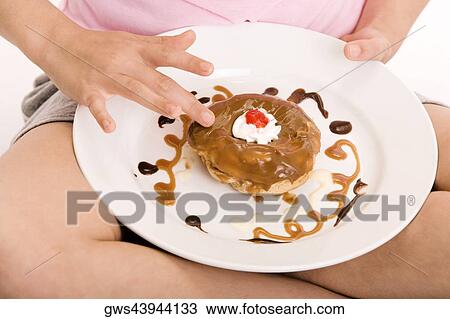 Mid section view of a girl holding a donut in a plate View Large Photo Image Stock Image - Mid section view of a girl holding a donut in a plate. Fotosearch